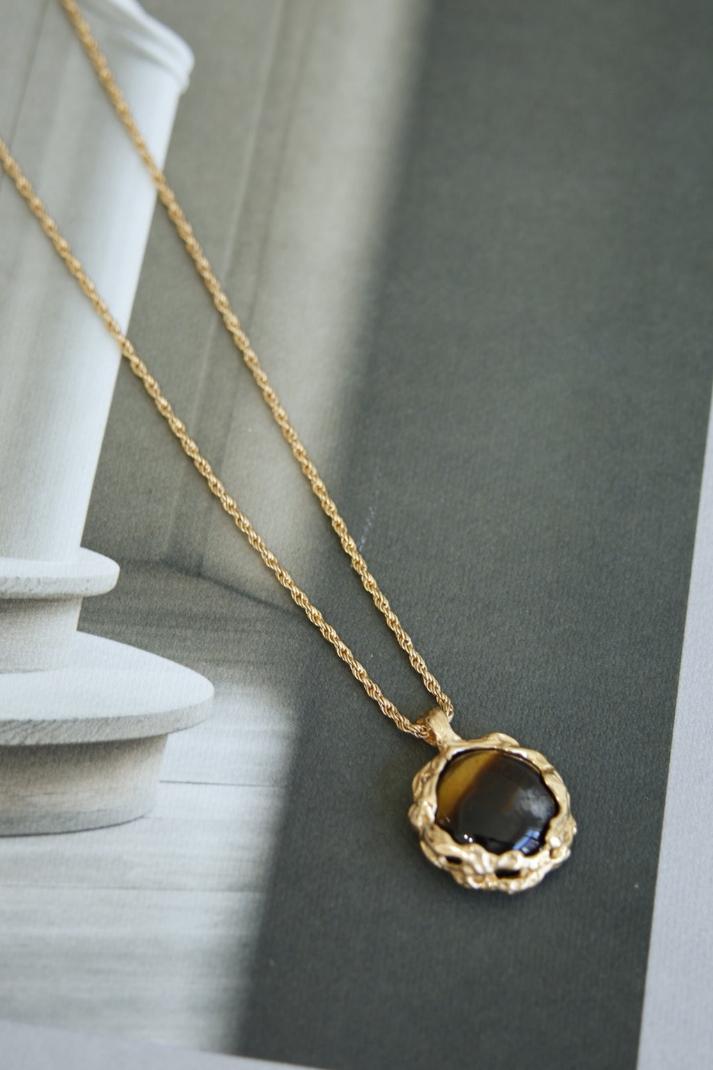 Hand-carved tiger's eye stone pendant with volcanic lava texture